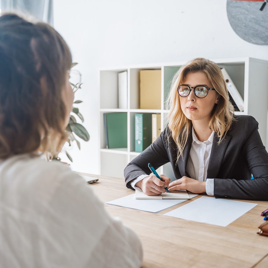 Young female candidate is interviewed by employer businesswoman